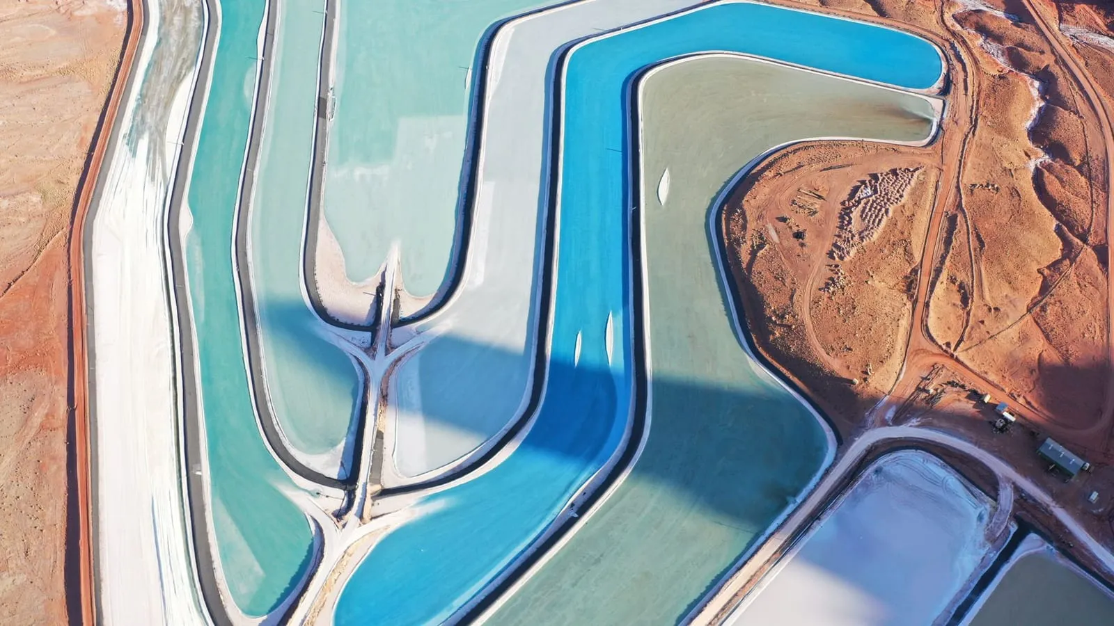 Stunning aerial shot of potash evaporation ponds in Moab, Utah, with vibrant blue hues.