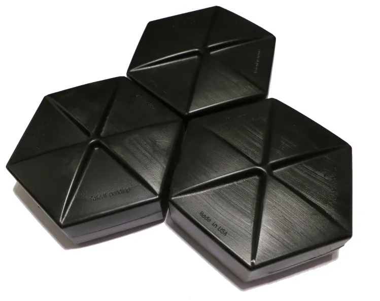 Three black interlocking hexagonal HDPE tiles (Hexprotect® AQUA), each scored into six triangular facets